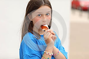 teen girl with lollipop is having fun. happy cool Kid in blue t-shirt with bright candy.