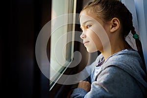 Teen girl look out of window outside. self-isolating.