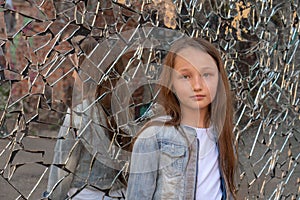 Teen girl looking at the camera. Reflection in a broken mirror. about the problems of adolescents. Transitional age