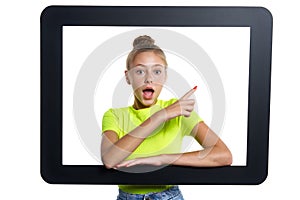 Teen girl looking through digital tablet frame pointing finger to side