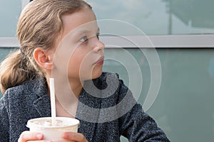 Teen girl, looking at the interlocutor, portrait, holding a drink with a straw photo