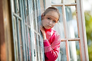 Teen-girl looks out the window rural house