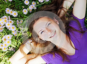 Teen girl lying in grass