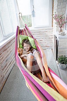 Teen girl lying in a hammock together in your favorite cat maine coon