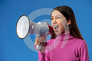 Teen girl making announcement with megaphone on blue background