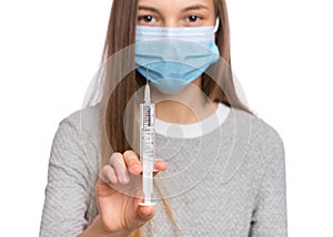 Teen girl in mask with syringe