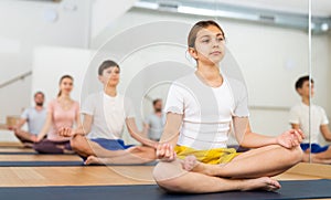 Teen girl meditating in Padmasana position during family yoga training