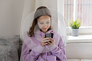 Teen girl obsessed with smartphone social media apps at home photo