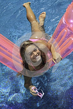 Teen girl in pink bikini on a float