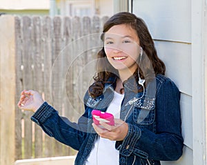 Teen girl playing music with smartphone earings photo