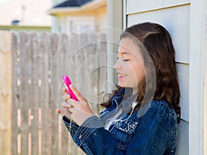 Teen girl playing music with smartphone earings photo