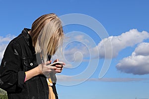 Teen girl playing online games by a smartphone