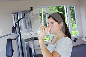 Teen girl with pony tail jogging on treadmill