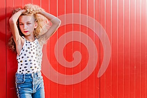 Teen girl posing on red wall background