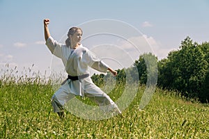 Teen girl practicing karate kata outdoors in kokutsu-dachi stance