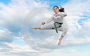 teen girl practicing karate. teen child jump on sky background. teen kid practicing martial art