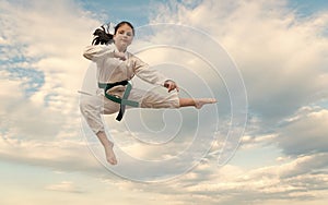 teen girl practicing karate. teen child jump on sky background. teen kid practicing martial art