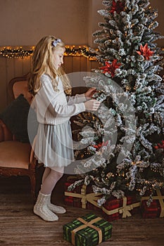 Teen girl with present near Christmas tree standing