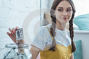 teen girl putting dollar banknote into