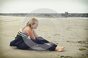 Teen girl putting on a wetsuit at Rockaway Oregon
