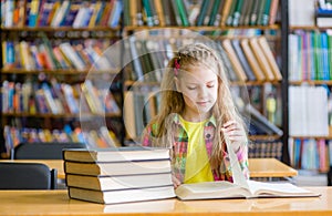 Teen girl reading a book in the library