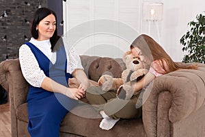 Teen girl on reception at the psychotherapist. Psychotherapy session for children. The psychologist works with the patient. Girl