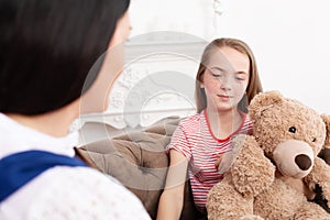 Teen girl on reception at the psychotherapist. Psychotherapy session for children. The psychologist works with the patient. Girl