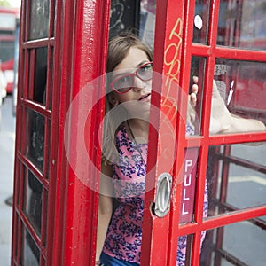 Teen girl in the red phone booth