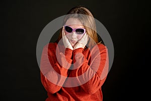Teen girl in red sweater with purple sunglasses