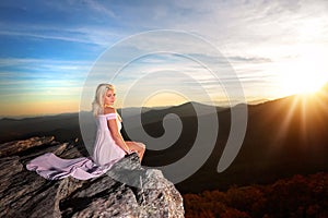Teen girl on a rock overlook in the mountains