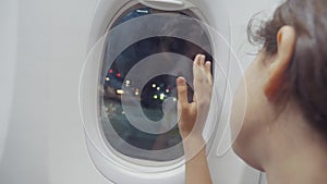 Teen girl says goodbye waving his lifestyle hand at the window of the plane aviation aircraft concept. young girl looks