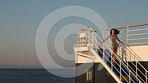 Teen girl in shorts standing on top of blue stairway on ferry boat