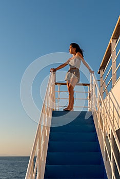 Teen girl in shorts and tube top standing on top stair