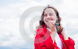 teen girl singing song in microphone on sky background, live music