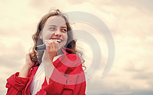 teen girl singing song in microphone on sky background, live music