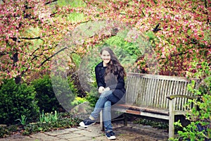 Teen Girl Sitting on Bench with Crab Apple Blossoms