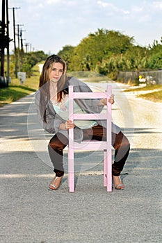 Teen Girl Sitting in a Chair in a Roadway (1)