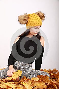 Teen girl sitting on dried leaves