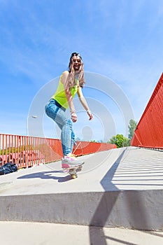 Teen girl skater riding skateboard on street