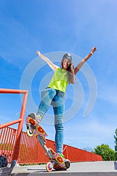 Teen girl skater riding skateboard on street.