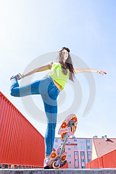 Teen girl skater riding skateboard on street.