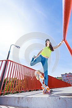 Teen girl skater riding skateboard on street.