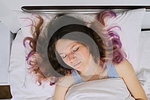 Teen girl sleeping at home in bed, view from above