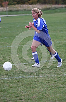 Teen Girl Soccer Player Chasing Ball