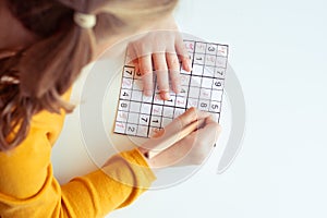 Teen girl solving sudoku at school or at home. View from above