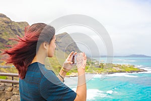 Teen girl standing above tropical Hawaiian ocean scenery