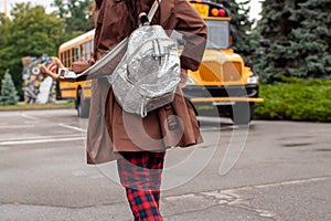 Teen Girl Standing Near Yellow School Bus Parked On The Street