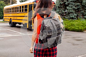 Teen Girl Standing Near Yellow School Bus Parked On The Street