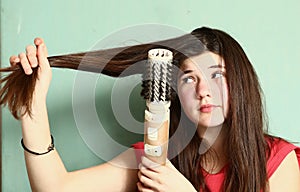 Teen girl straighten her long brown hair photo