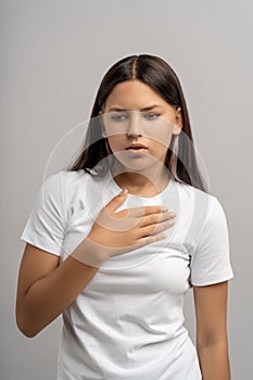 Teen girl suffer from breathing problems, panic attack, suffocation holding hand on chest isolated